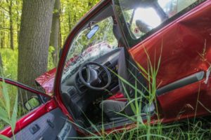 Car crashed in a tree while trying to avoid a speeding vehicle.
