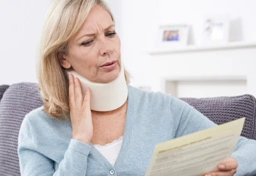 Woman in pain wearing neck brace